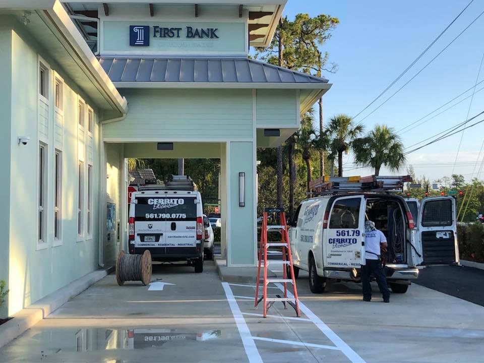 Two Cerrito Electric vans parked at the drive through of a First Bank branch under construction